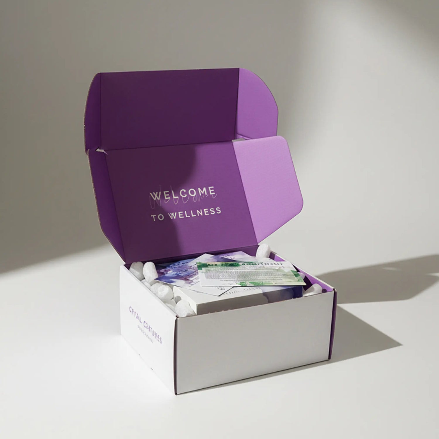 Open box with 'Welcome to Wellness' text on a light background