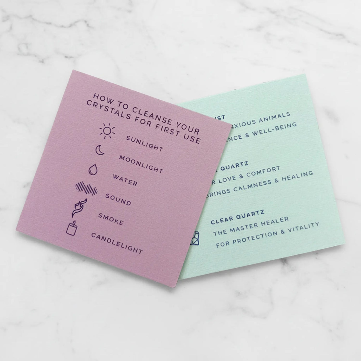 Two cards with text and icons on a marble surface